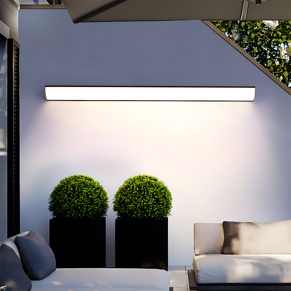 Modern exterior wall light mounted horizontally above twin decorative garden planters