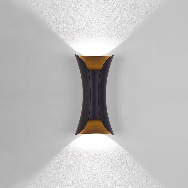 Modern black and gold hourglass LED outdoor wall light casting a sharp V-shaped beam