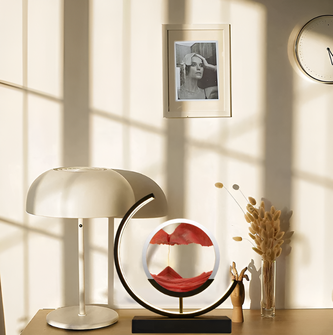 Modern sand art bedside lamp with a black frame and orange sand styled on a wooden desk