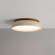 Modern round travertine and wood flush mount ceiling light glowing warmly