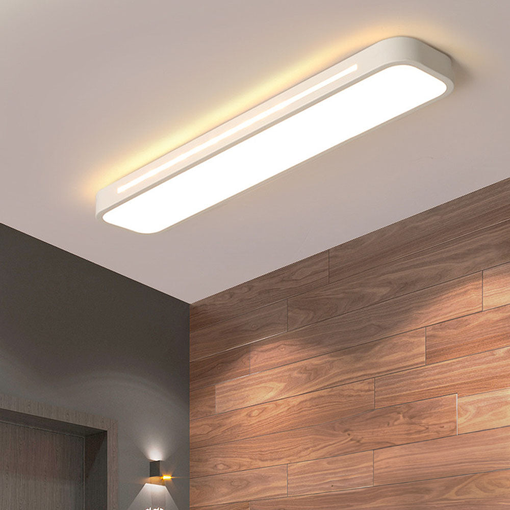 Modern white linear LED flush mount ceiling light illuminating a room with wood panelling