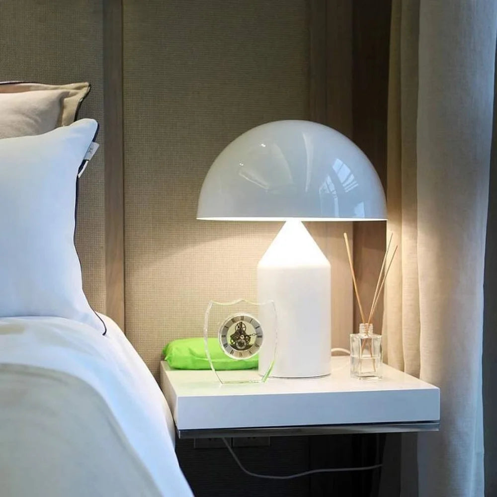 Modern white mushroom table lamp illuminating a sleek contemporary bedside table