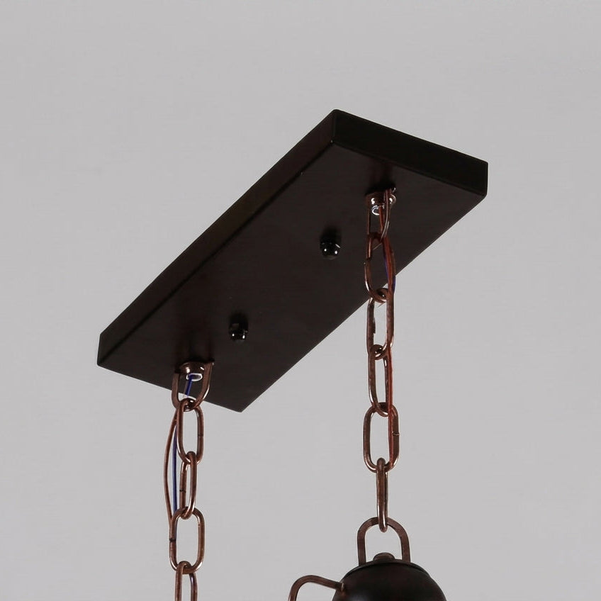 Close-up of the Mupzi chandelier's black ceiling mount canopy and chain suspension