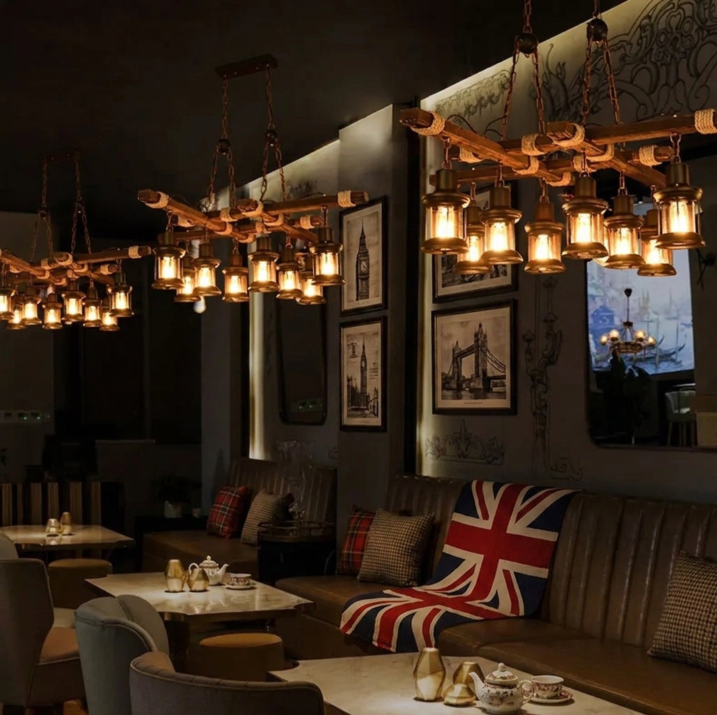 3 Mupzi industrial wood beam chandeliers with rope-wrapped joints hanging above booth seating in a British-style restaurant