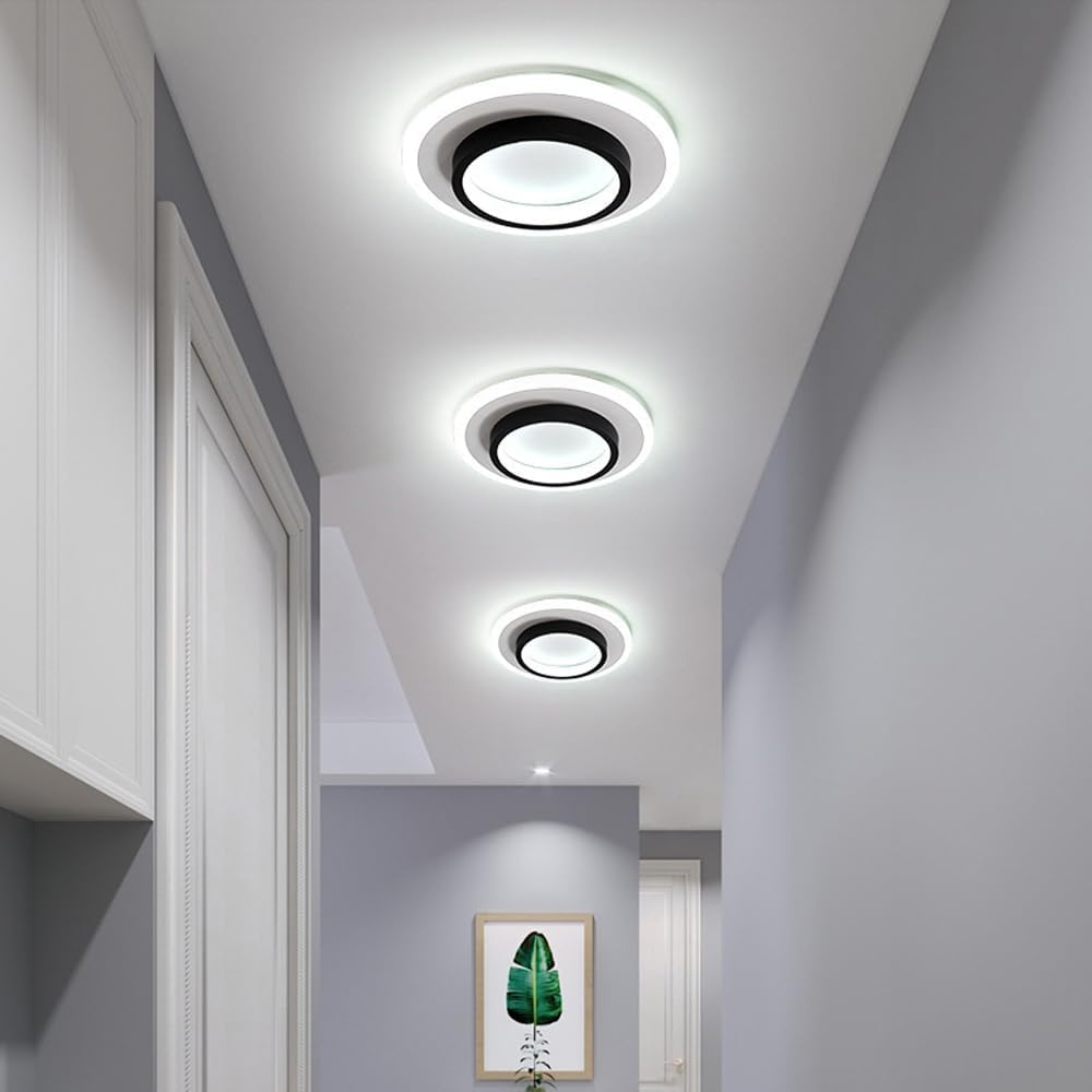 Three black geometric halo LED flush mount mura lights installed in a row down a modern grey corridor
