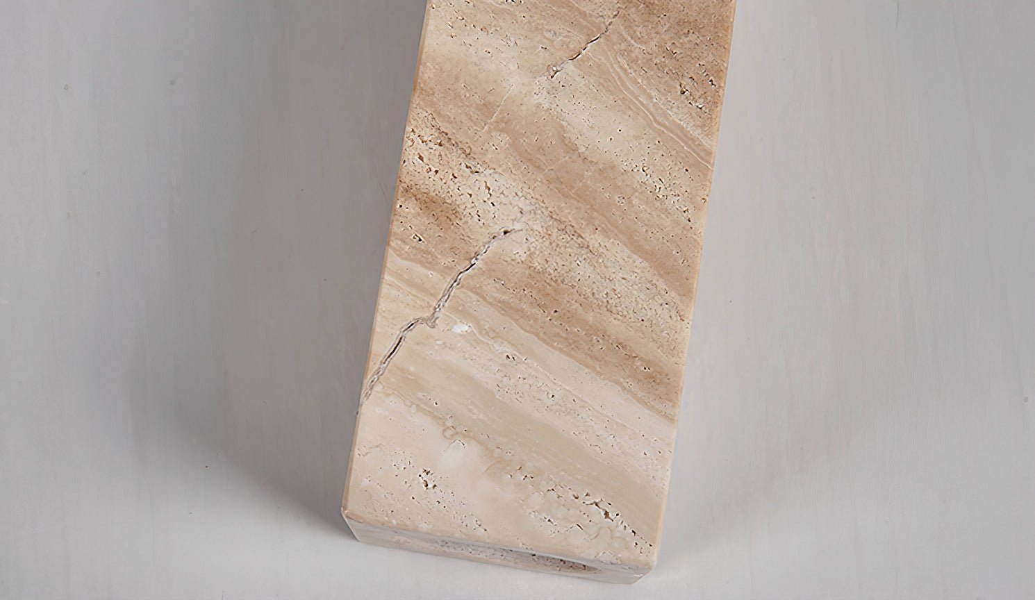 Close-up detail of a raw natural yellow travertine stone slab, showing its unique geological pores and veining