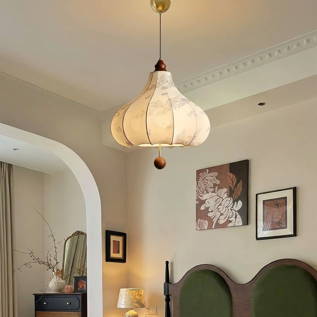 Naxlu pendant light in a bedroom with wall art and wooden headboard with green upholstery