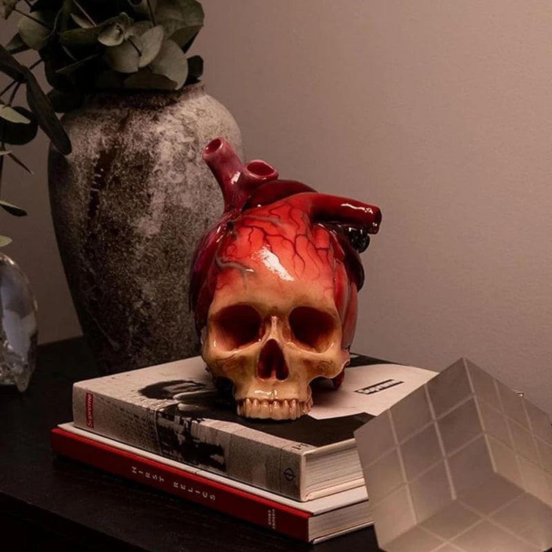 Necrovalve anatomical heart and skull resin ornament styled on a desk with a vase and decorative accents