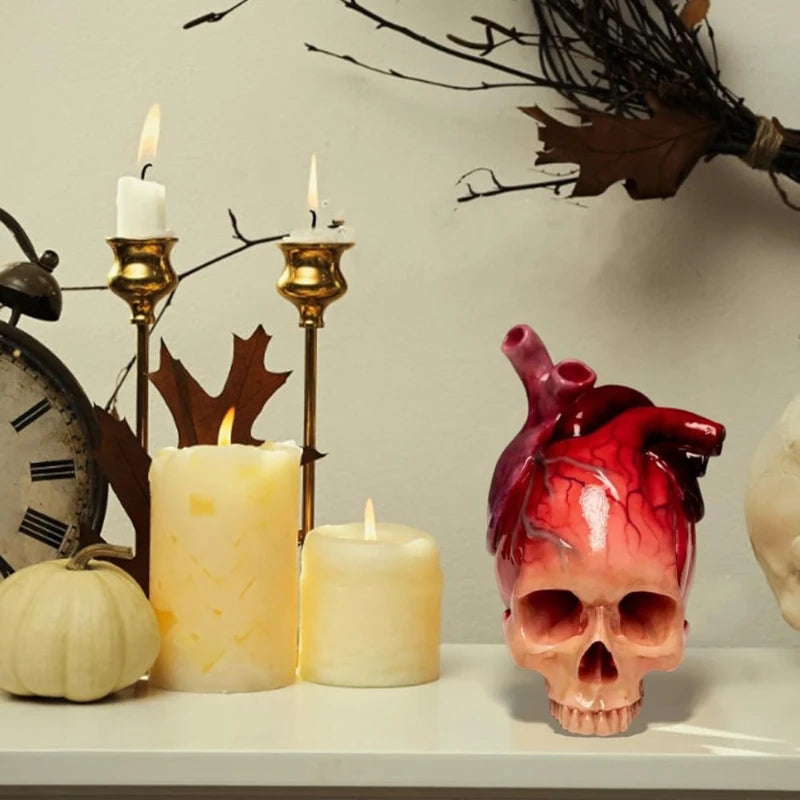Necrovalve anatomical heart and skull resin ornament displayed on a mantel with candles and a pumpkin