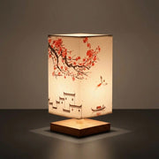 Nimza Red Blossom table lamp with cherry blossom fabric shade lit on a dark background