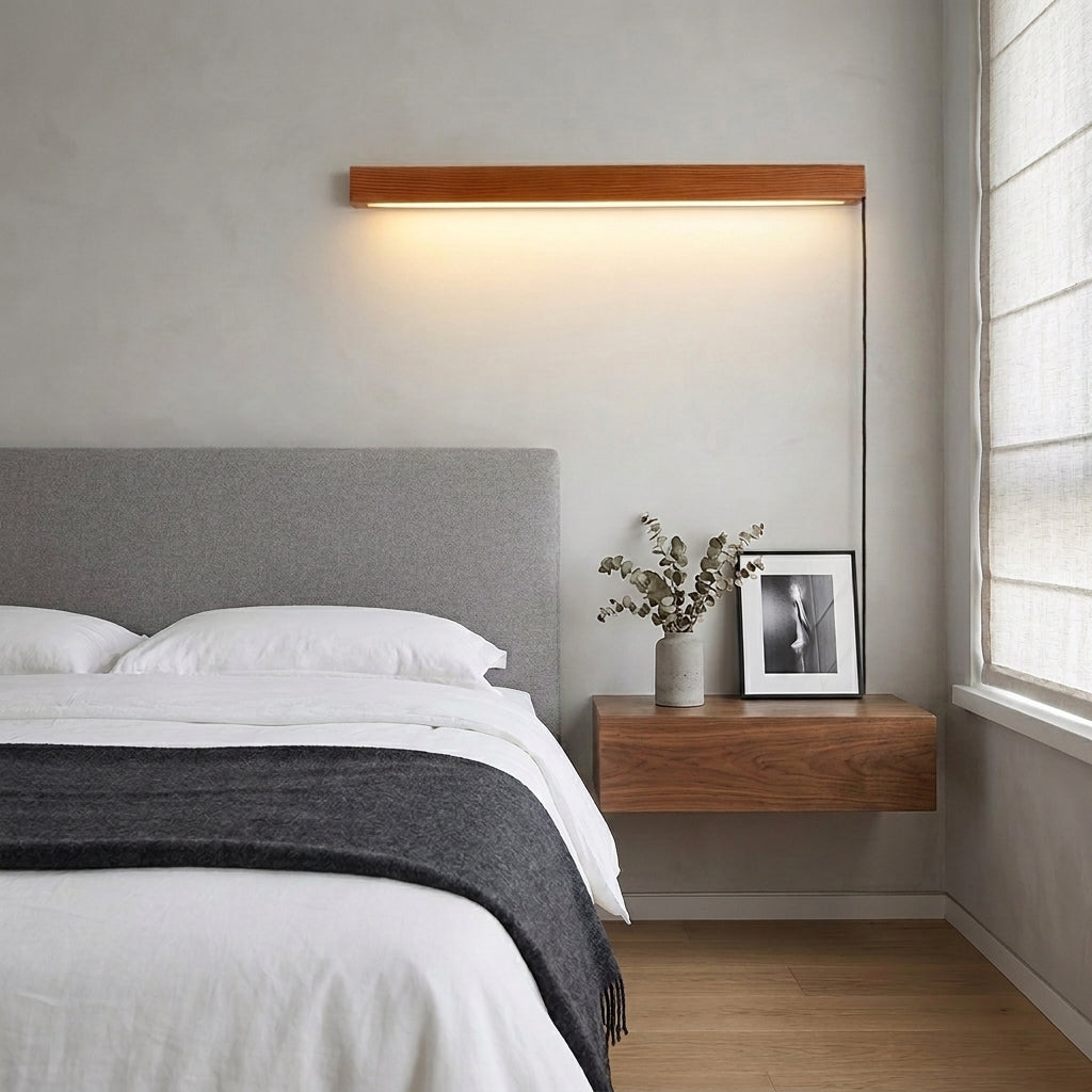 Nizku linear wood wall lamp above a bed with a floating nightstand and framed art