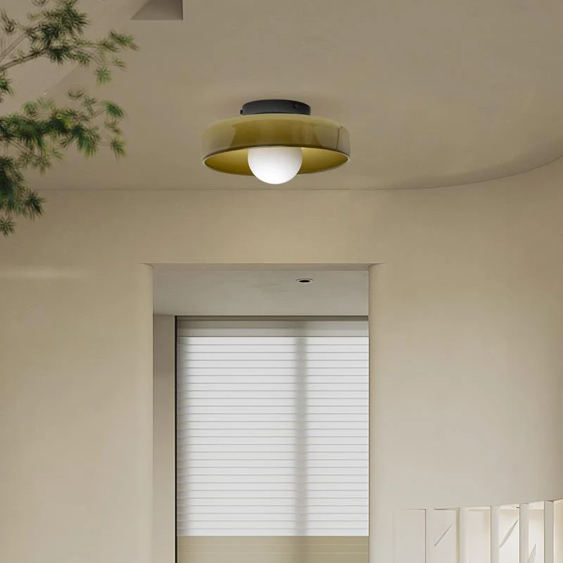 Olive green glass semi-flush mount ceiling lamp illuminating a bright, neutral bedroom