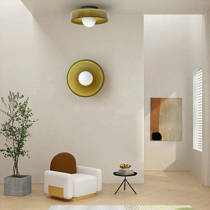 Olive green glass wall sconce and matching ceiling light in a modern minimalist room