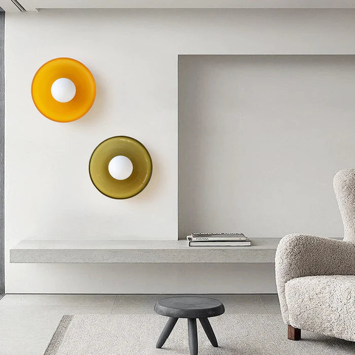 Orange and olive green glass wall sconces styled together in a modern interior