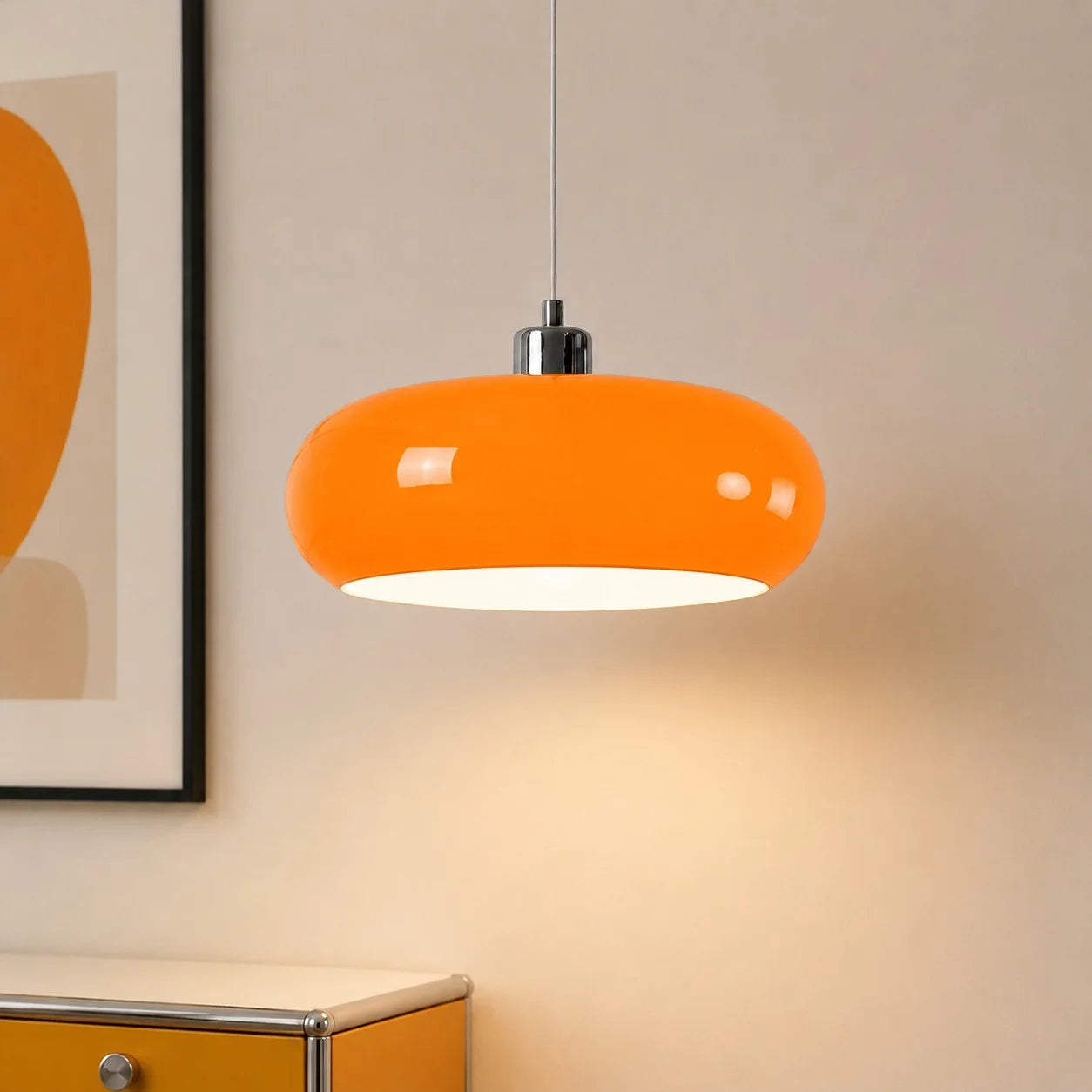 Orange Bauhaus glass dome pendant light illuminating a yellow cabinet and minimalist artwork