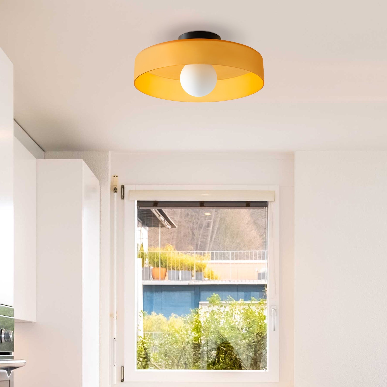 Orange glass ceiling lamp bringing a vibrant pop of colour to a modern kitchen entryway