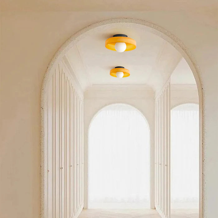 Pair of orange glass ceiling lights illuminating a stunning arched architectural hallway