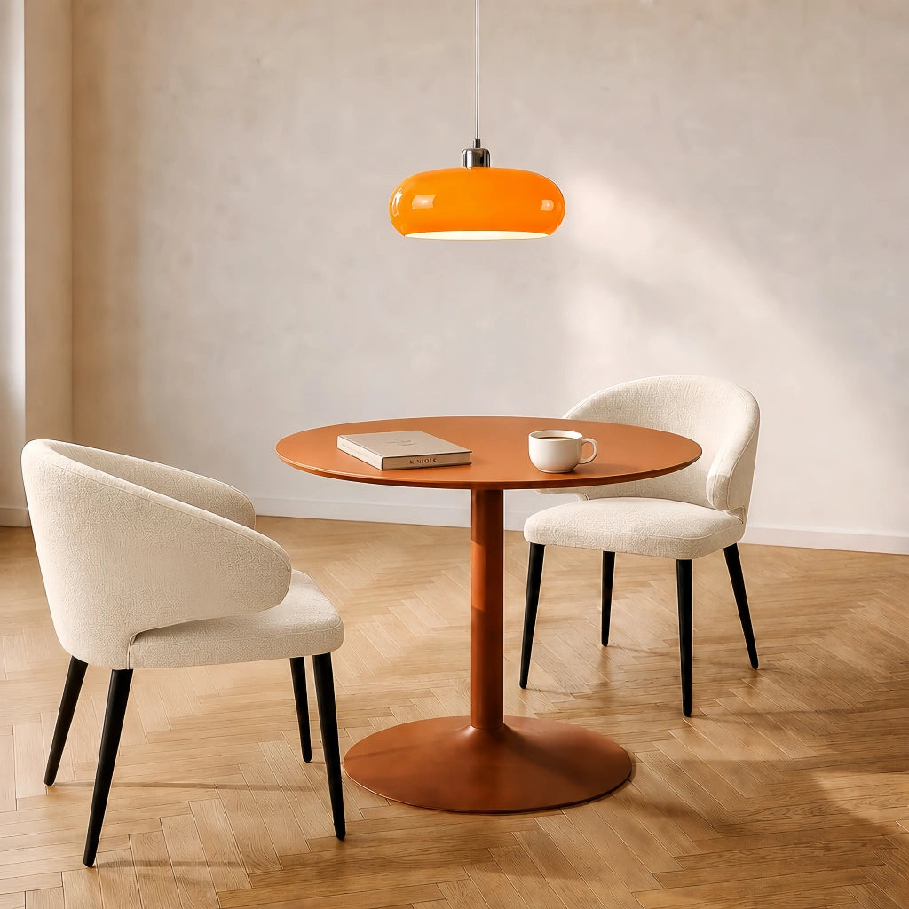 Orange glass dome pendant light illuminating a cosy modern dining nook with a wooden table and two chairs