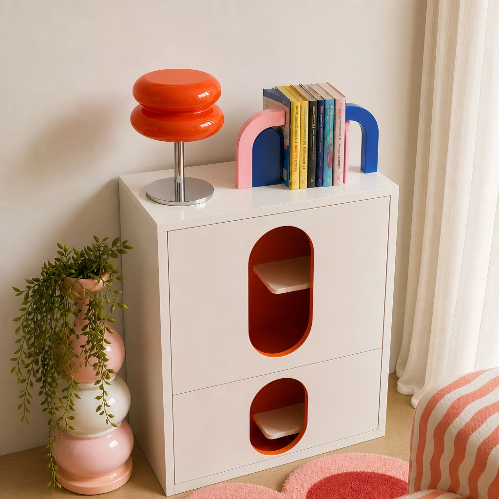 Vibrant orange macaron glass accent lamp adding a pop of colour to a modern white cabinet