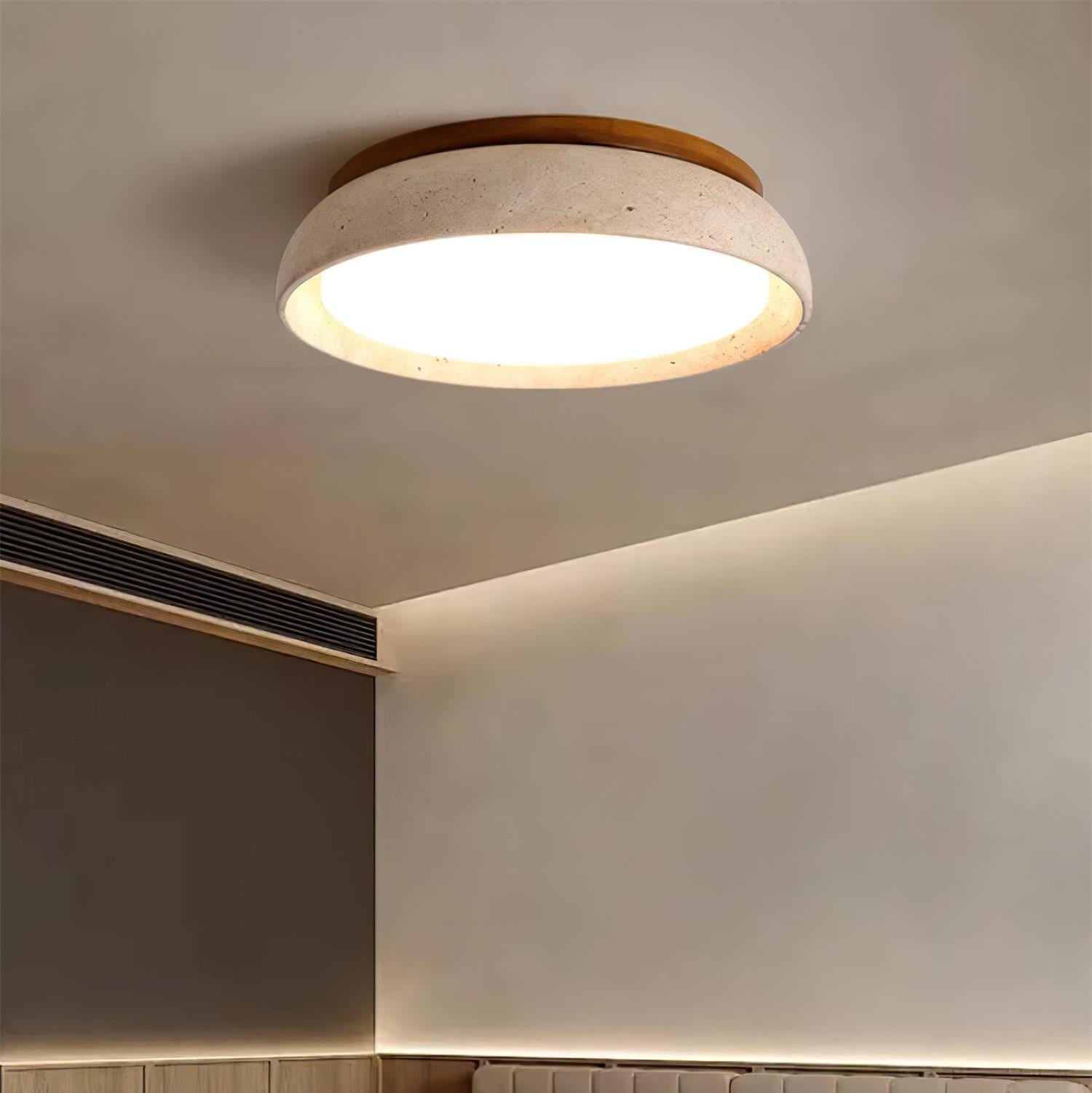 Organic stone flush mount ceiling light providing warm ambience in a moody bedroom