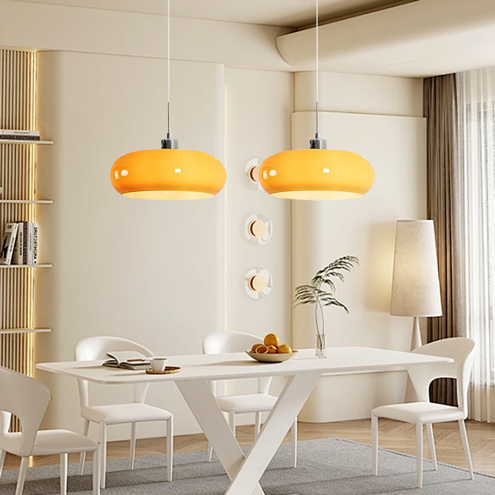 Pair of brown hand-blown glass ceiling pendants lighting up a bright, contemporary white dining space