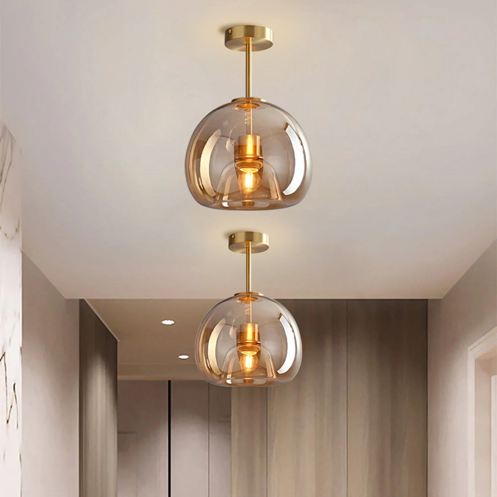 Pair of compact amber tinted glass ceiling lights in a bright, warm hallway corridor