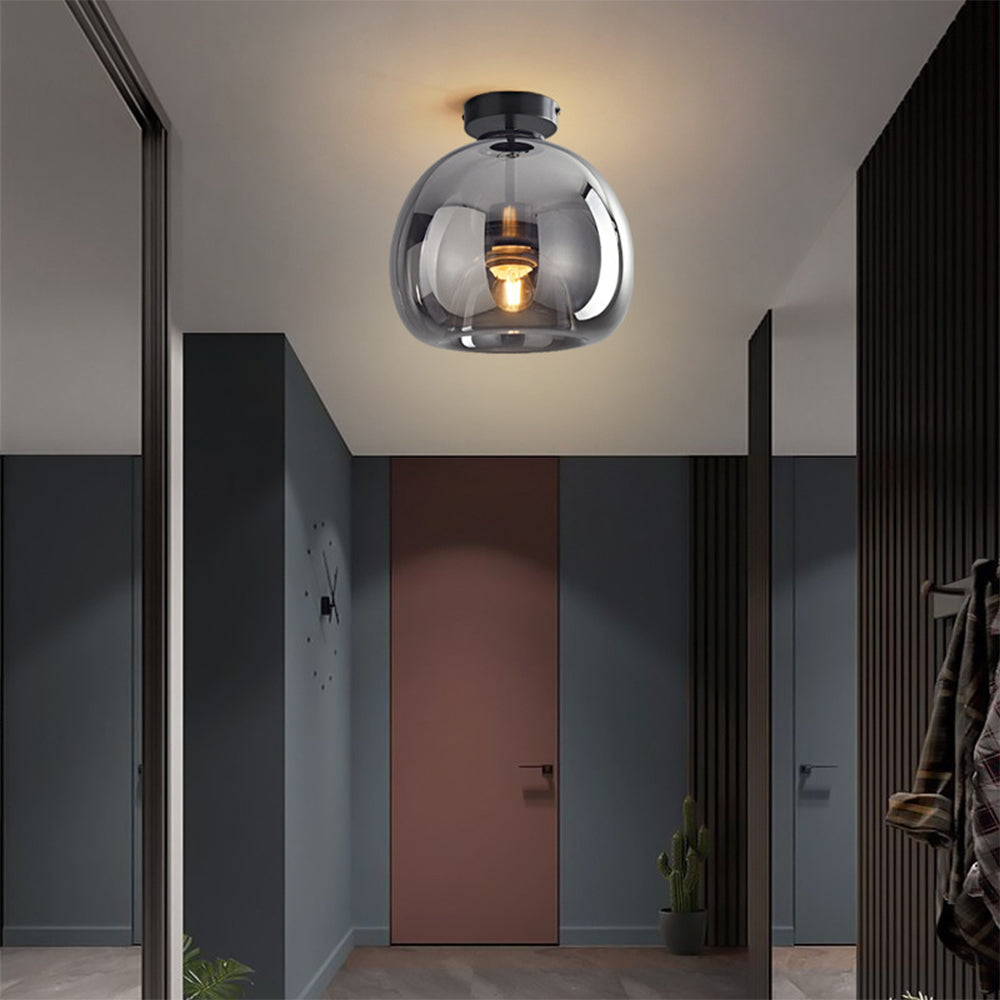Modern smoke grey retro glass globe flush mount pawo ceiling light illuminating a contemporary entryway