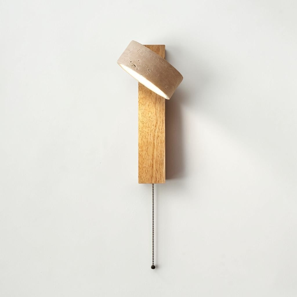 Pexni wabi sabi wall light with rotatable travertine stone and a pull cord hanging on log wood backplate, mounted on a white wall