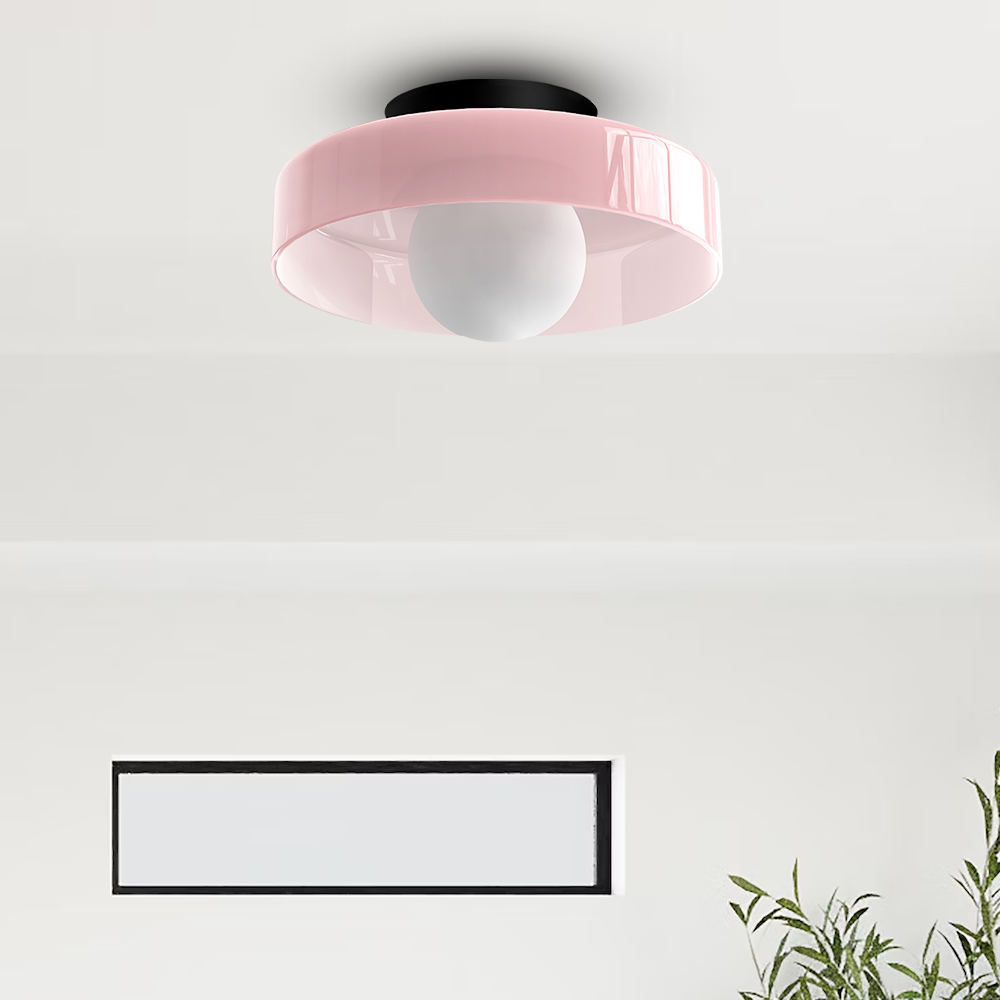 Pink glass disc flush mount ceiling light in a romantic, light-filled bedroom