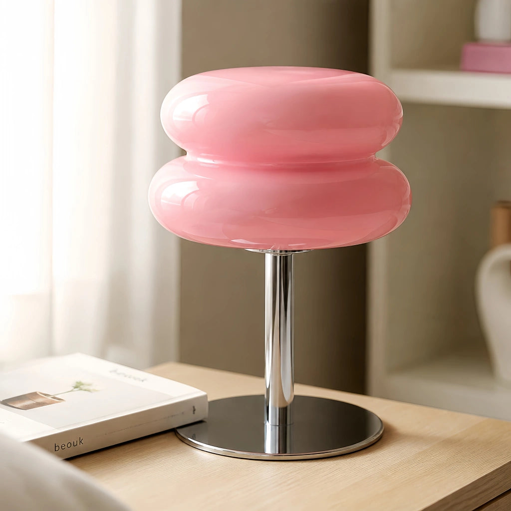 Soft pink glass macaron desk lamp resting gracefully on a minimal wooden table