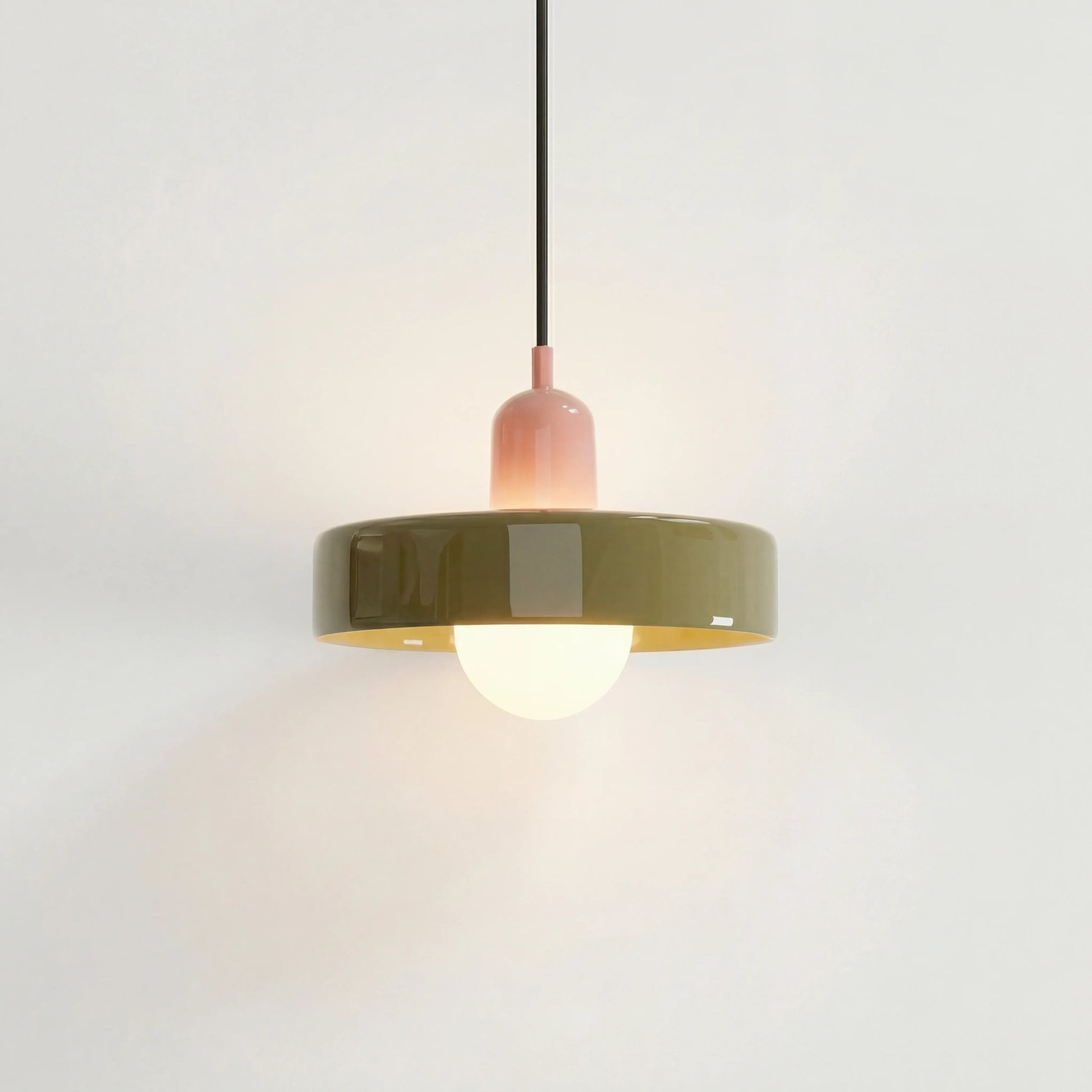 Pink and green mid-century pendant light suspended elegantly against a white wall