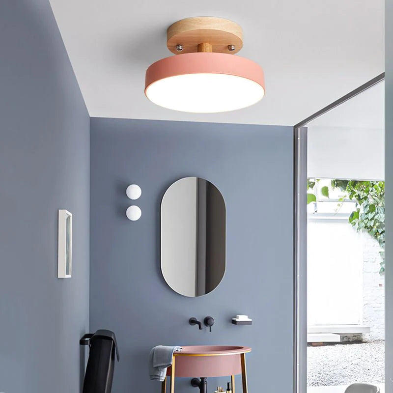 Pink modern semi flush mount ceiling light illuminating a contemporary bathroom vanity area