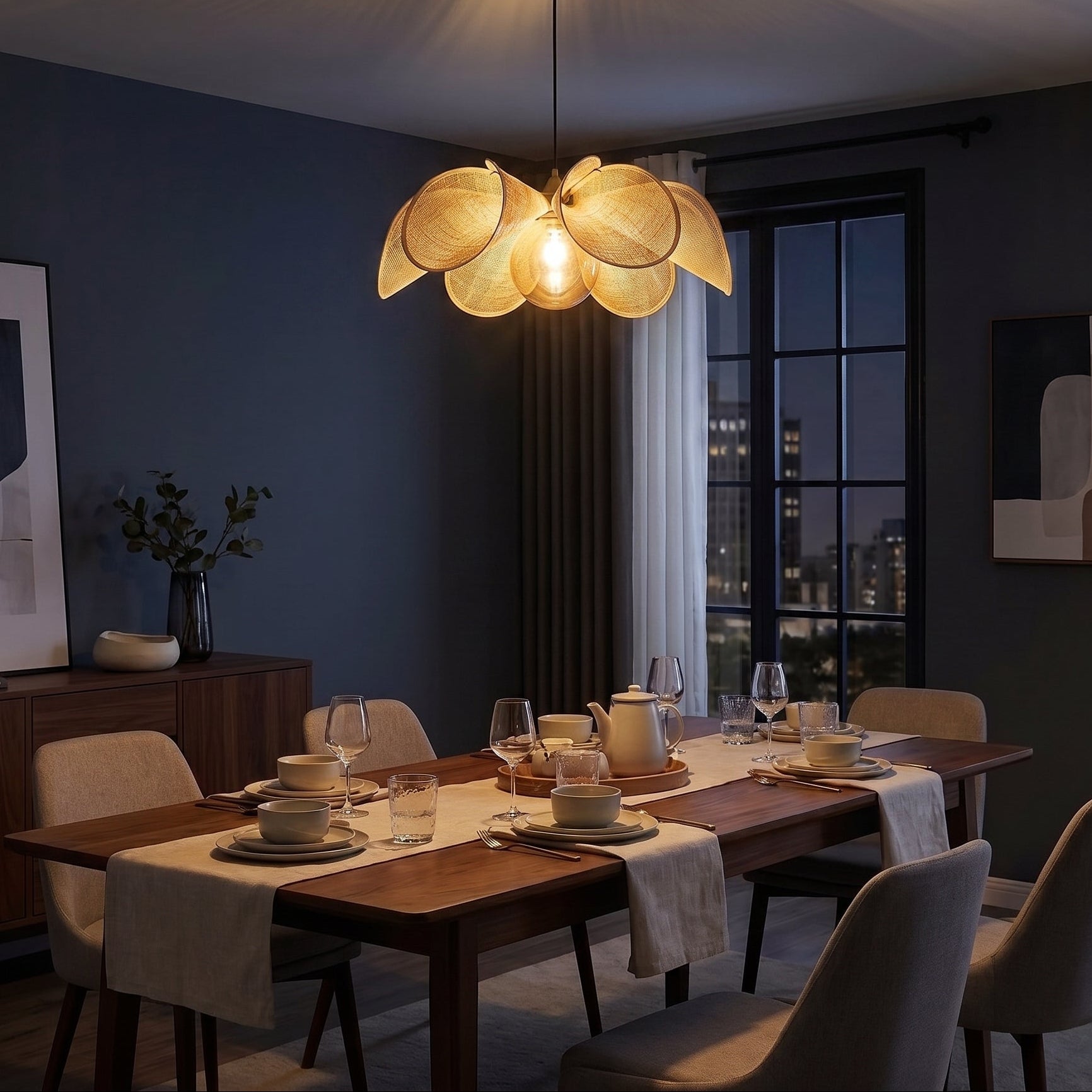 Puvzo rattan lotus pendant light lit above a dining table in a dark blue dining room
