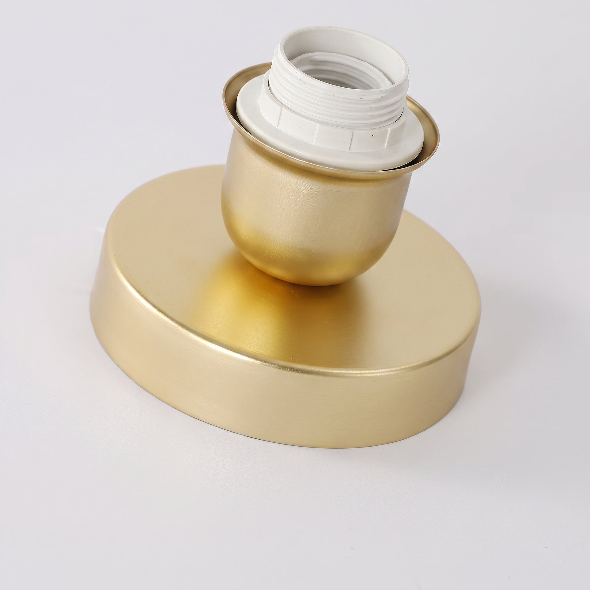 Close-up of the Qavlu brushed gold canopy and base fitting without the glass shade
