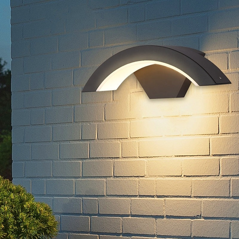 qaxo modern black arched LED outdoor wall light illuminating a white brick exterior wall