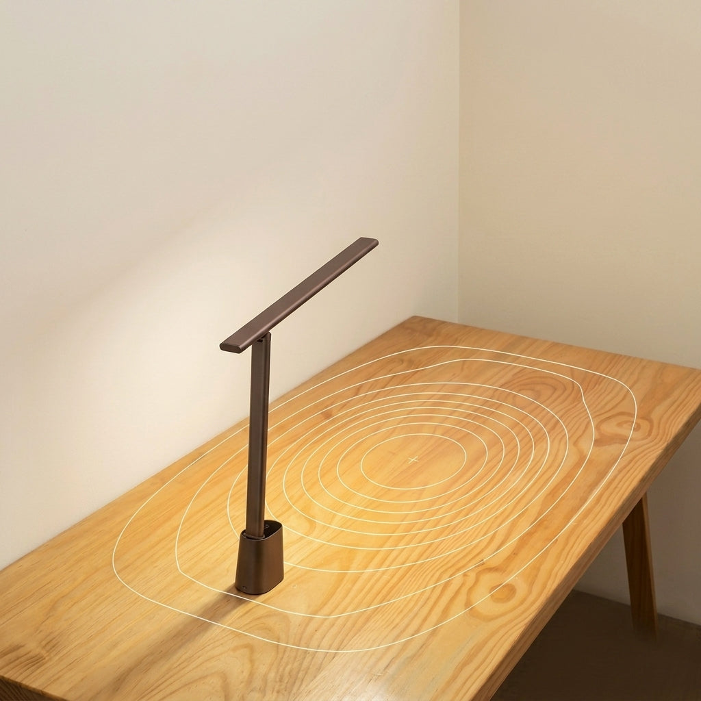 A modern qeta LED desk lamp with a minimalist rectangular head and cylindrical base, shown standing on a light wood table against a plain beige wall.