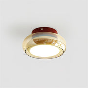 Modern retro flush mount ceiling light featuring a red metal base and an amber tinted glass shade