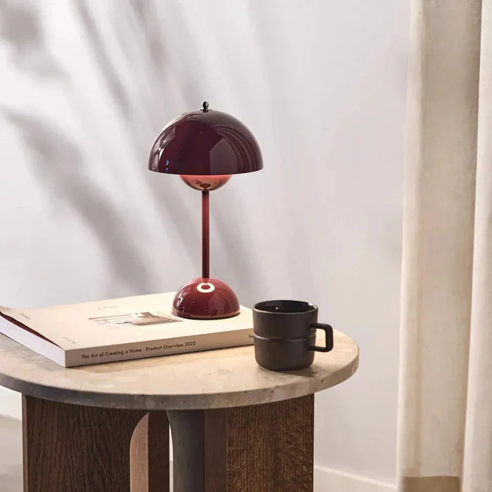 Vibrant red cordless dome table lamp styled on a round wooden side table