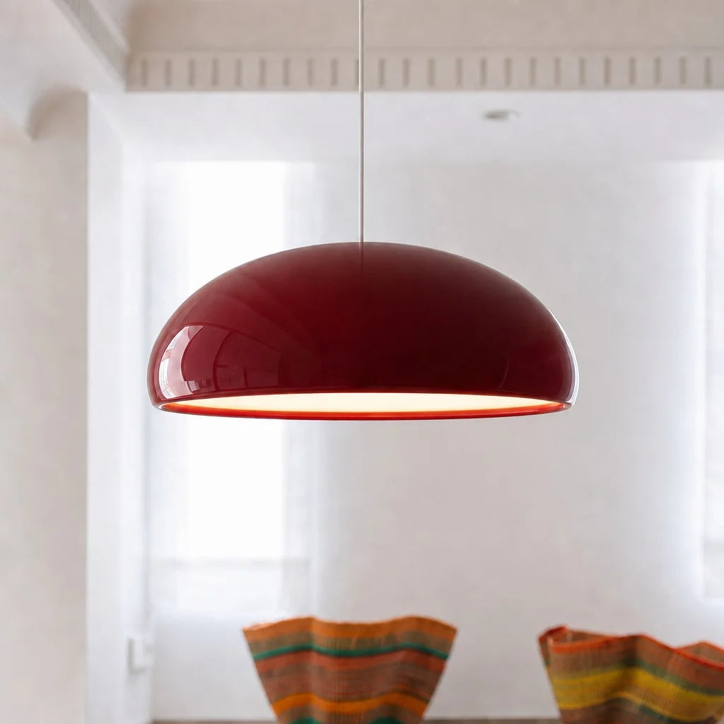 Red mid-century dome pendant light suspended over a stylish dining table setup