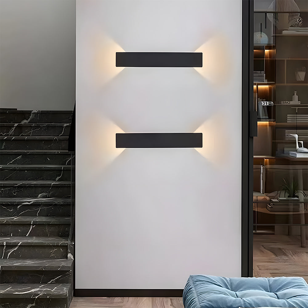 Two slim black reta wall sconces mounted horizontally as modern indoor living room lighting