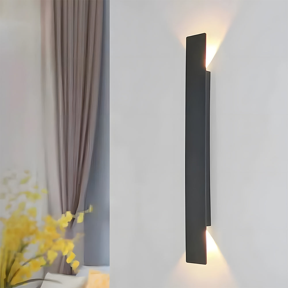 Slim black reta LED wall sconce used as stylish indoor ambient lighting in a living room