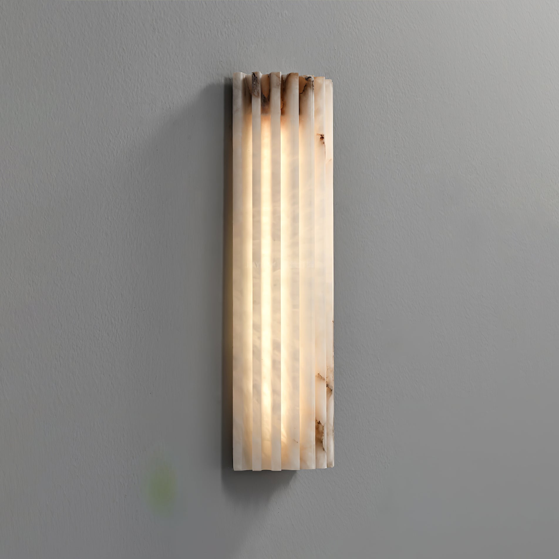 ribbed alabaster stone wall light showcasing its raw, organic texture and earthy veins