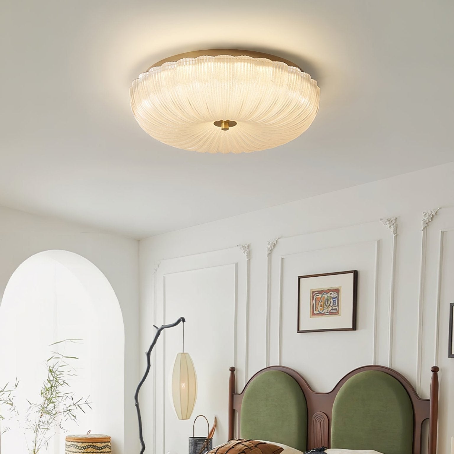 Ripple glass ceiling fixture providing soft ambient light above a green velvet bed