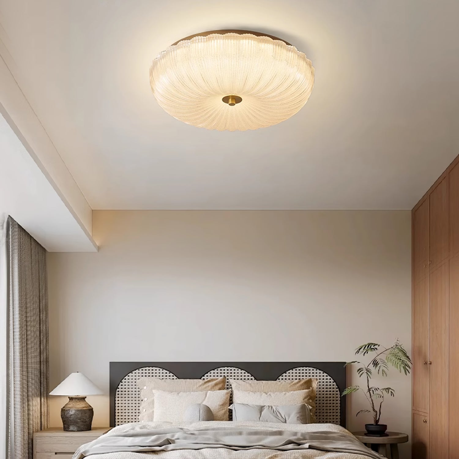 Modern ripple glass flush mount ceiling light illuminating a minimalist bedroom