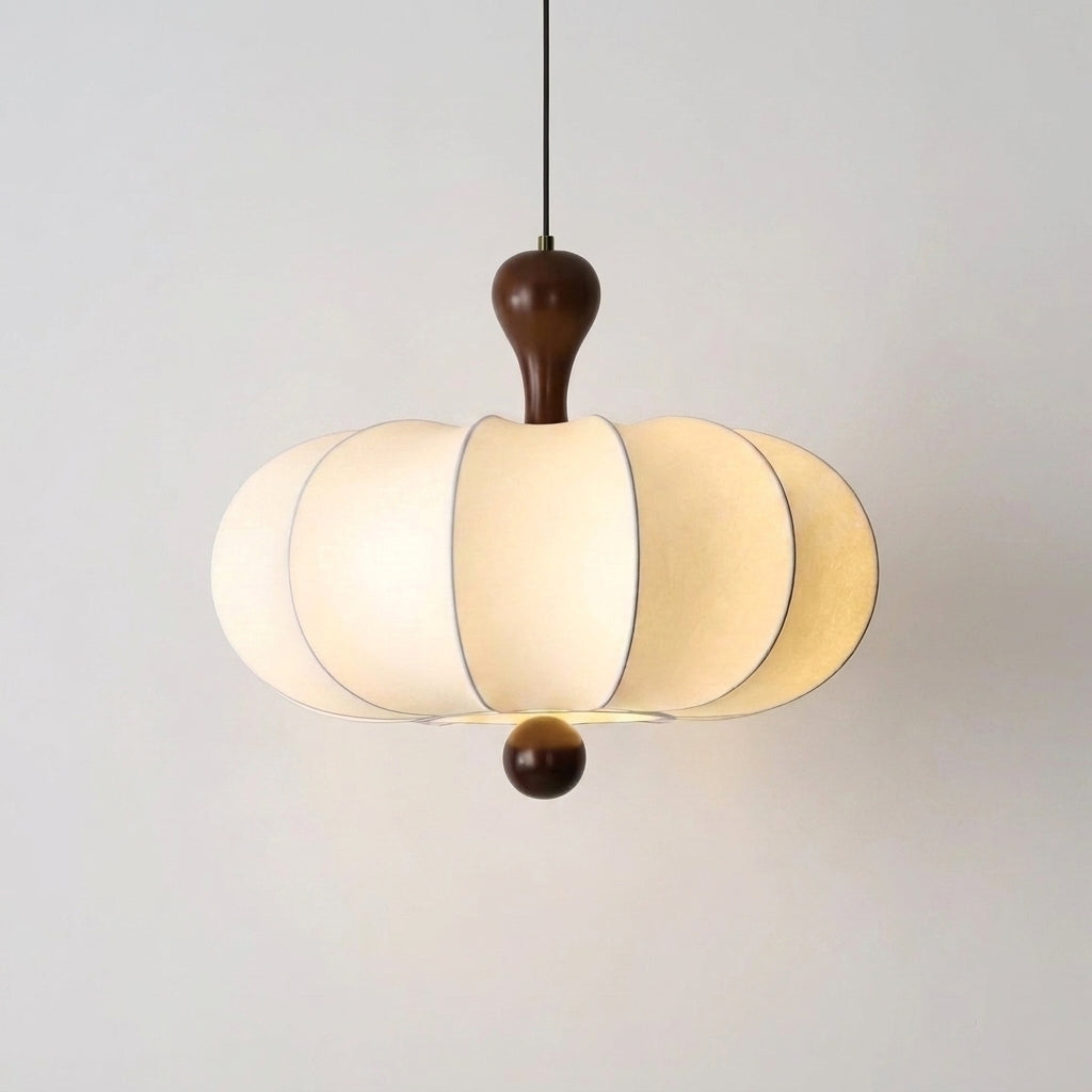 Rizqo wabi sabi fabric pendant light with walnut wood cap, illuminated on a white wall