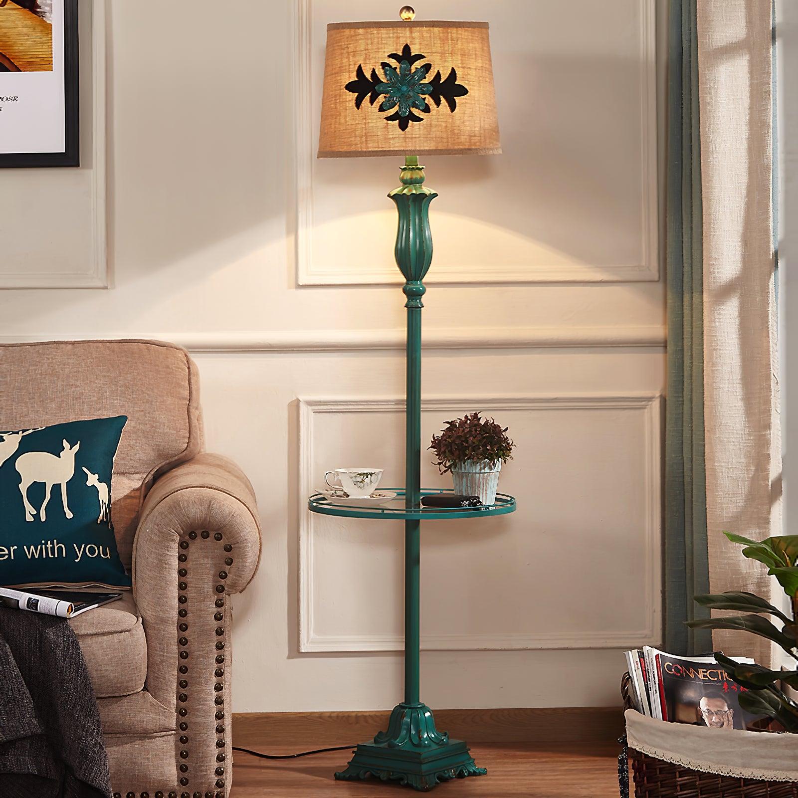 Rustic green standing lamp with an integrated table providing warm ambient light next to a classic sofa