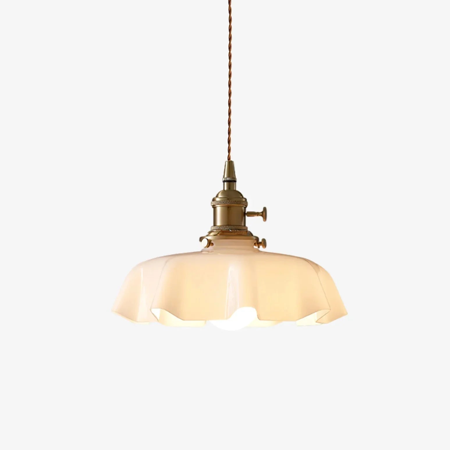 Isolated view of the vintage scalloped cream glass pendant highlighting its braided cord and antique brass fitting