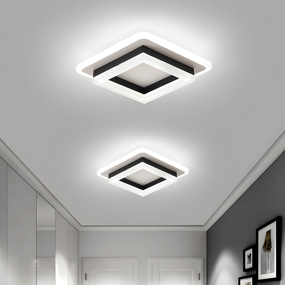 Two modern black geometric square LED flush mount serq ceiling lights installed in a bright contemporary hallway