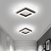 Two modern black geometric square LED flush mount serq ceiling lights installed in a bright contemporary hallway