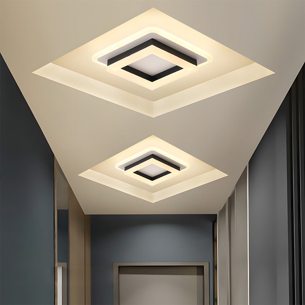 Pair of black geometric square serq ceiling lamps providing crisp cool white light in a dark corridor